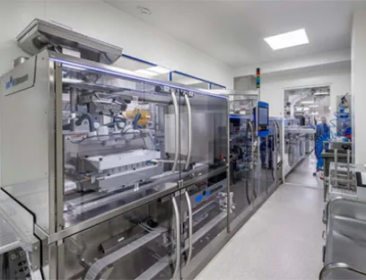 Für die Verpackung der hochpotenten Medikamente wurde die Blistermaschine in der Primärzone aufgestellt, dahinter folgen in Sekundärzonen die Form- und Deckfolienzuführung sowie die Kartonierung und Endverpackung, Bild: Uhlmann Primärzone bei Develco Pharma