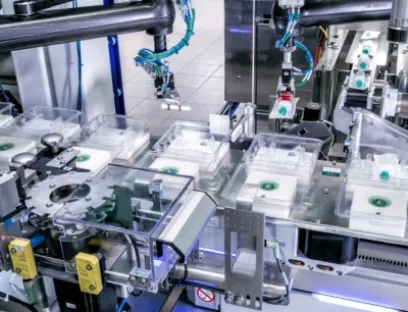 Ein F4-Pick-und-Place-Roboter entnimmt die hängenden Kolbenstangen aus dem Sternrad. Durch eine Kippbewegung in die Horizontale kann der Roboter die Kolbenstangen ablegen, Bild: Schubert Pharma Ein F4-Pick-und-Place-Roboter entnimmt die hängenden Kolbenstangen