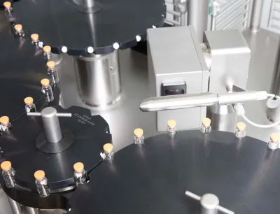 Eine Auflicht-Linienbeleuchtung von ETW Wollmershäuser unterstützt die Produktkontrolle auf einer Bausch+Ströbel Bördelmaschine